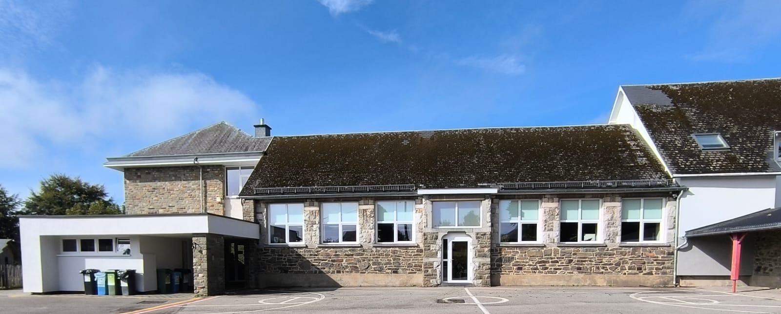 Le bâtiment en pierre de l'école communale de Sourbrodt, vu depuis la cour